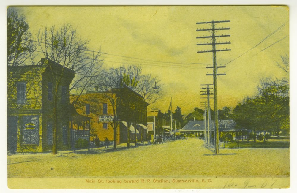 By September 1907: Colour postcard: “Main St. looking toward R.R. Station”